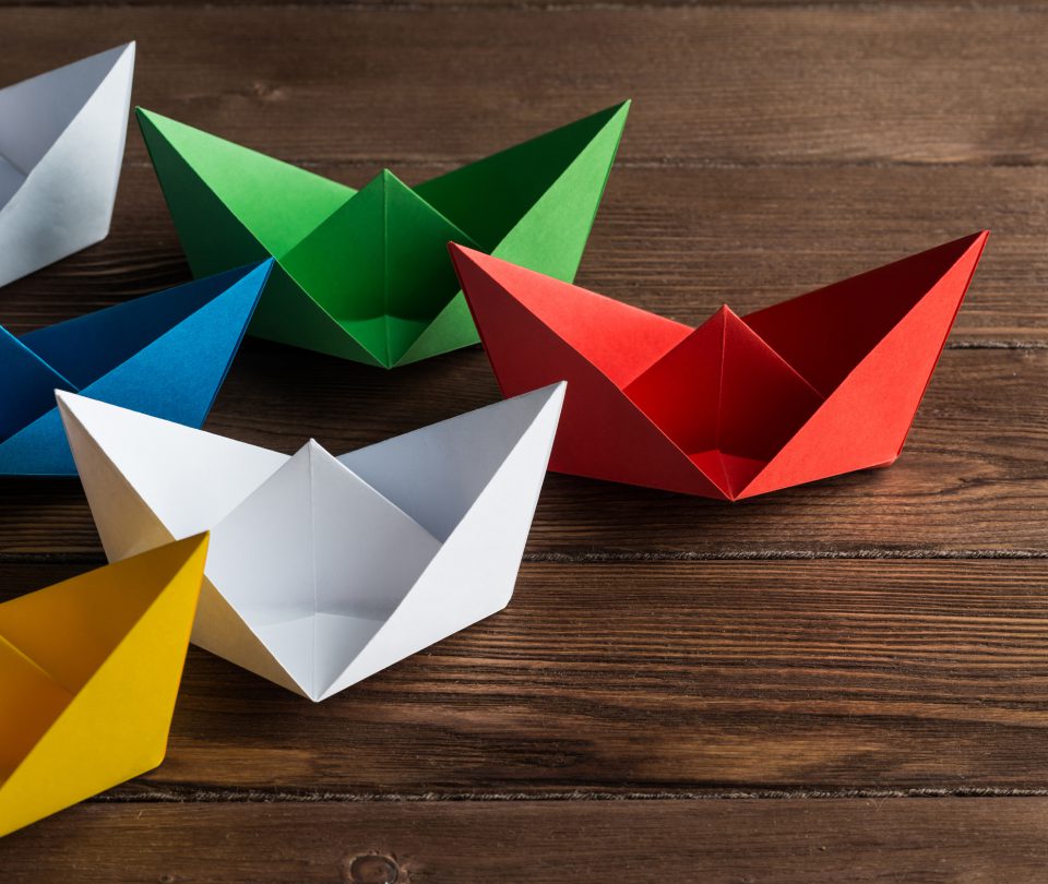 Bunte Papierboote als Symbol für individuelle digitale Lösungen